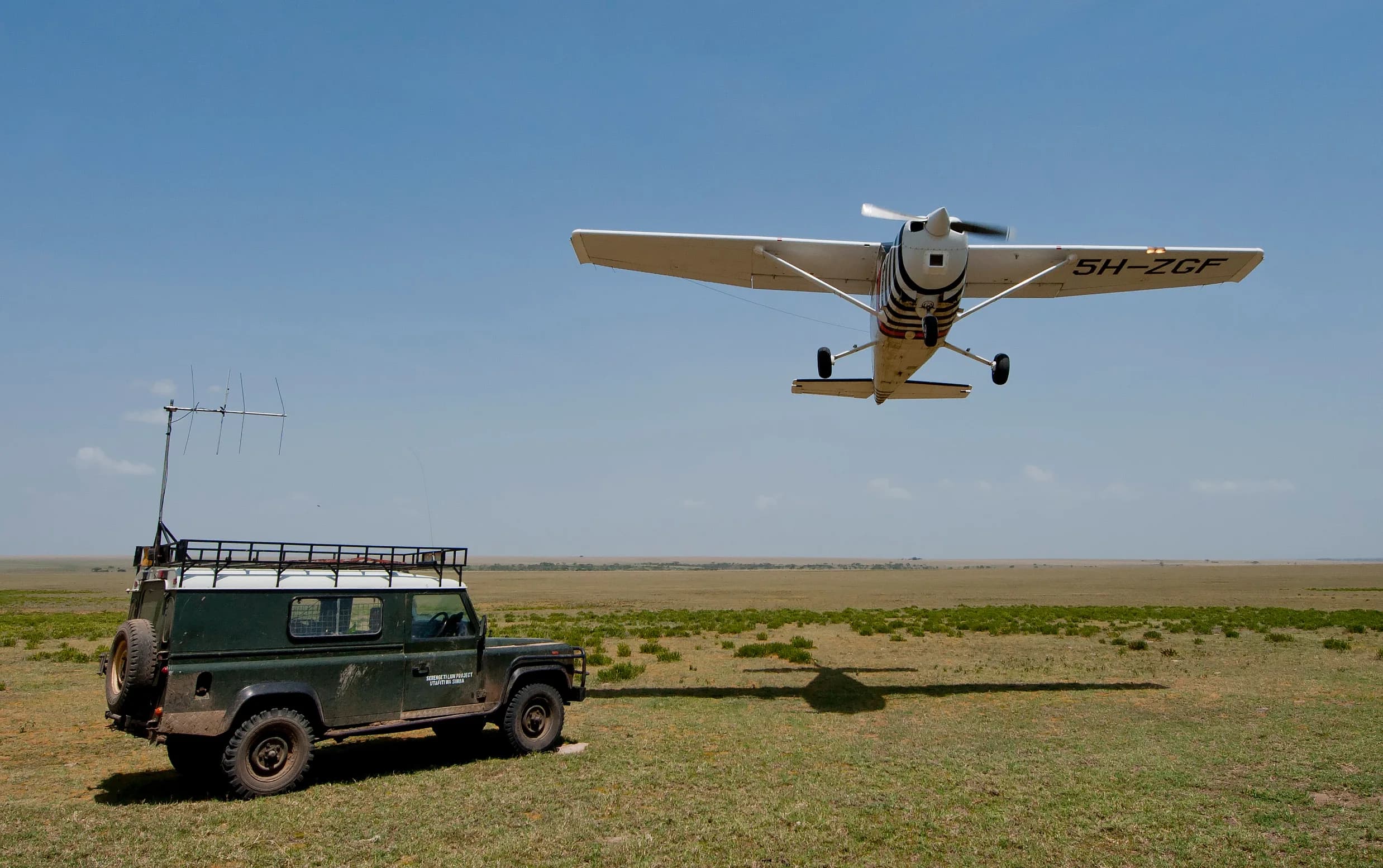 The interior of a safari vehicle with an open roof hatch and empty window seats